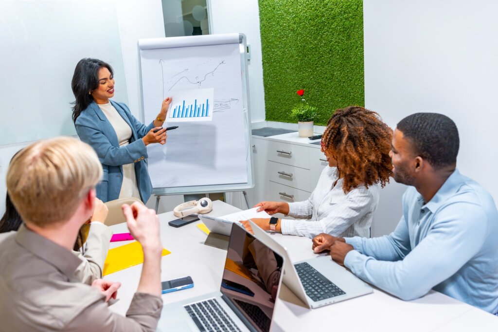 Young manager presenting marketing data to colleagues in meeting room